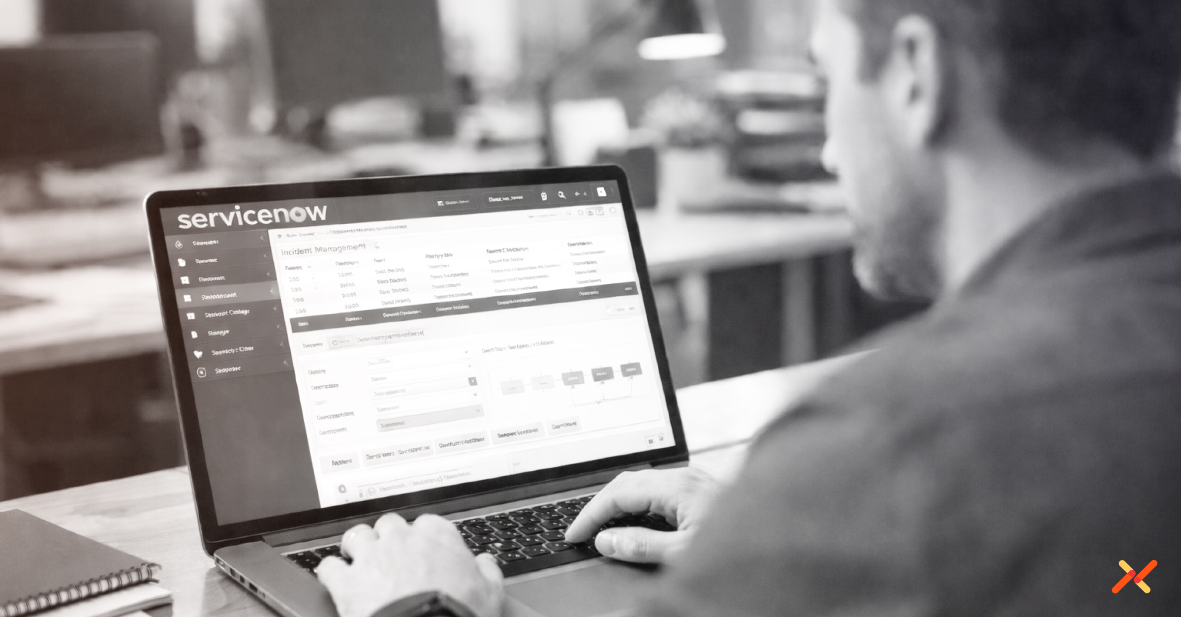 Man working on laptop with ServiceNow software running.