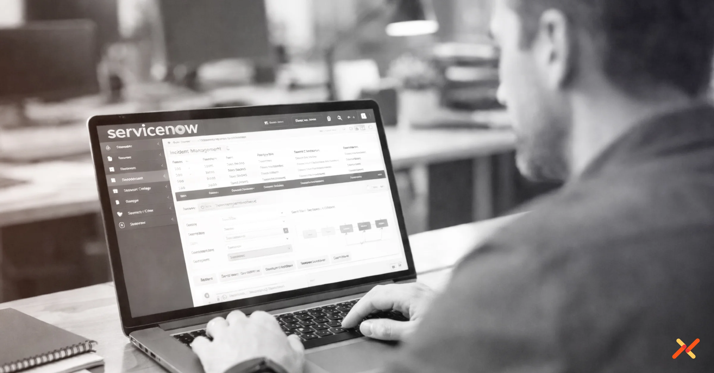 Man working on laptop with ServiceNow software running.